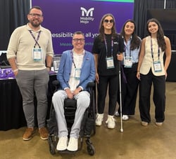 The Mobility Mojo team smiling together at their stand at a conference