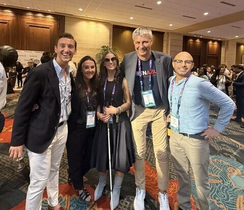 Two Mobility Mojo team members smiling with conference attendees, including Frank Justus from Bayer