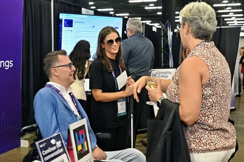 Stephen Cluskey and Bobbie Hickey chatting with a visitor at the Mobility Mojo stand