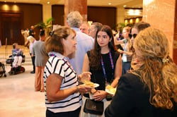 A Mobility Mojo team member in conversation with attendees at a conference reception