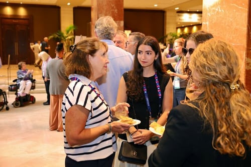 A Mobility Mojo team member in conversation with attendees at a conference reception