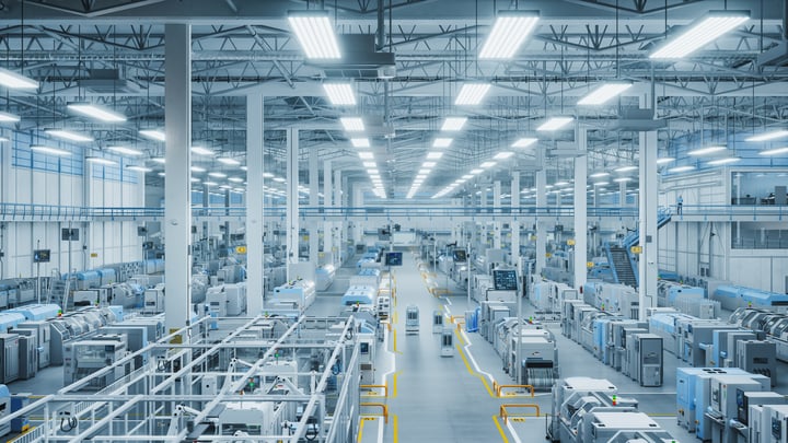 This image shows a large, well-lit industrial manufacturing facility with rows of machinery and equipment. The space appears organized and efficient, with a focus on productivity and automation.