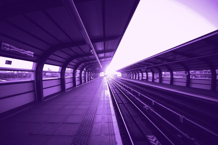 An empty station platform at sunset, tactile paving running the length of the platform edge