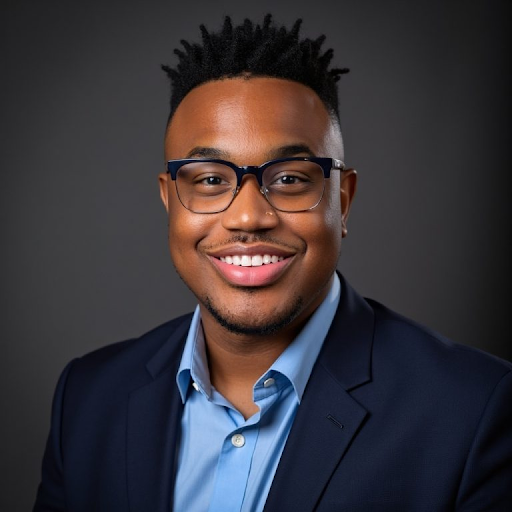 Headshot of Ky'lend Adams; a man with short, black hair wearing a suit.
